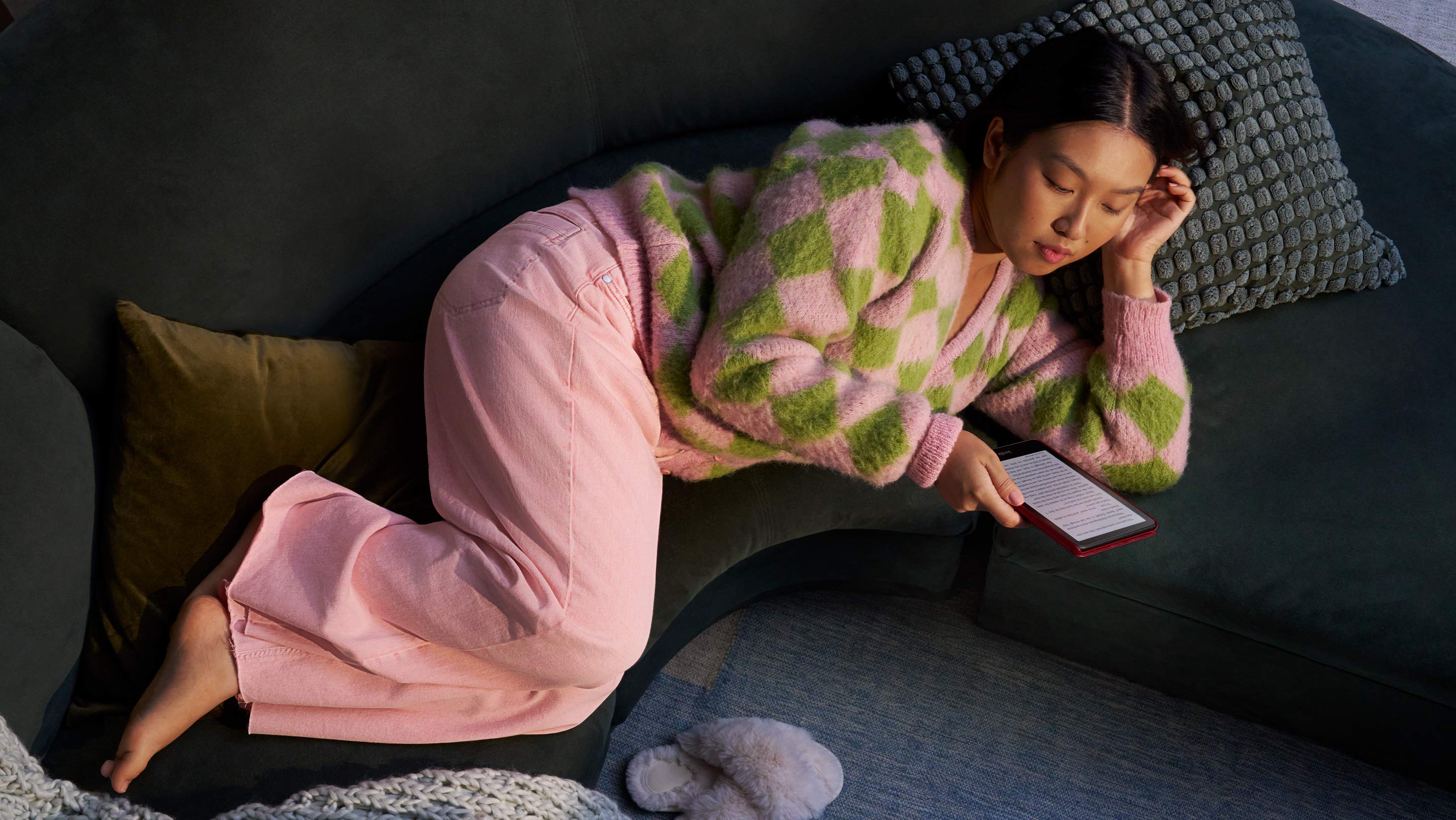 Mujer leyendo de noche en un sofá con su Kindle Colorsoft