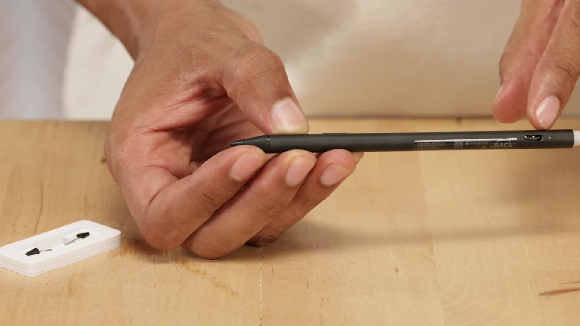 Manos mostrando el puerto USB-C del Kobo Stylus 2 junto a sus puntas de repuesto