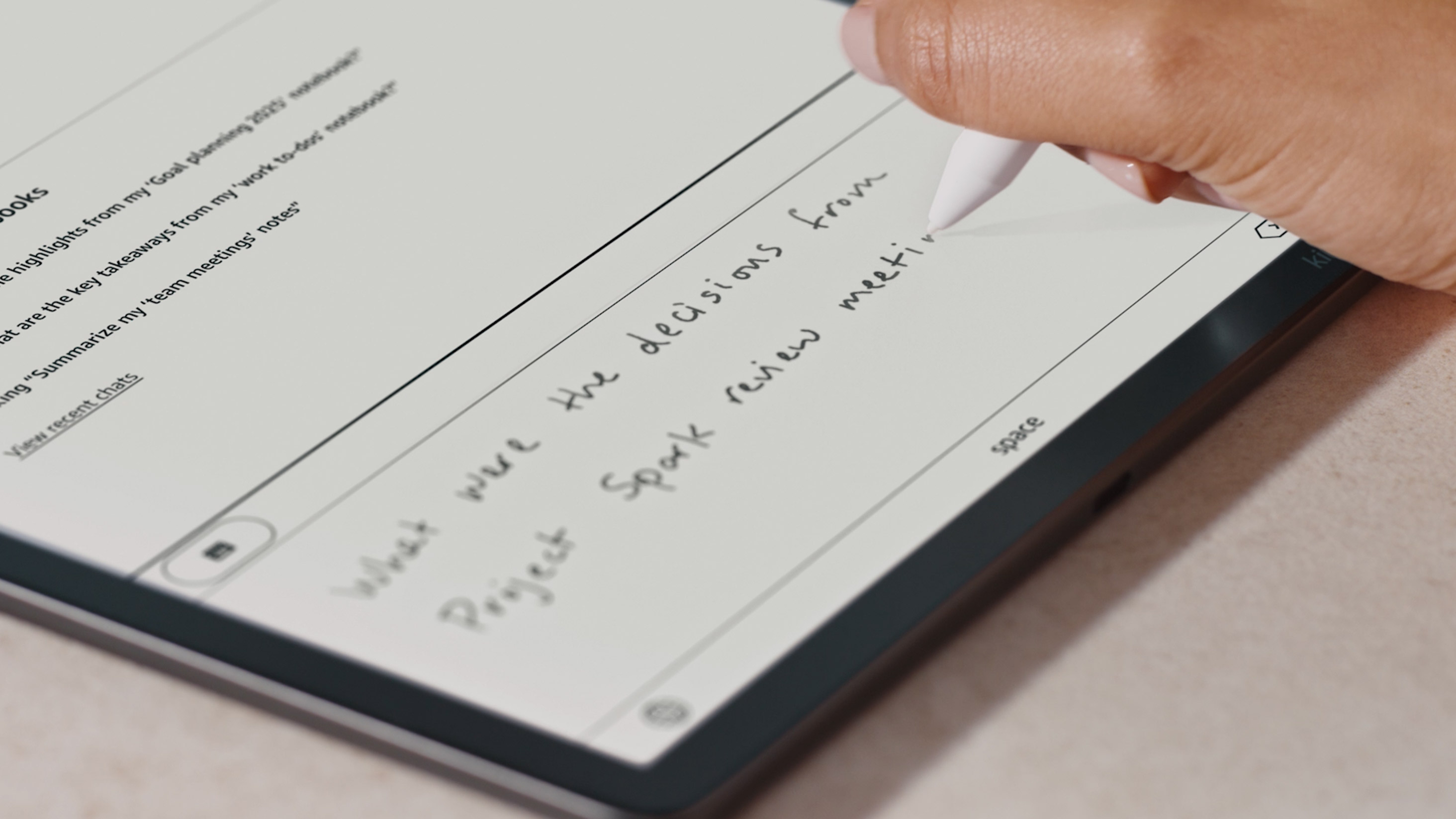 Mano escribiendo una pregunta con el lápiz para que la IA busque en los cuadernos del Kindle Scribe Colorsoft