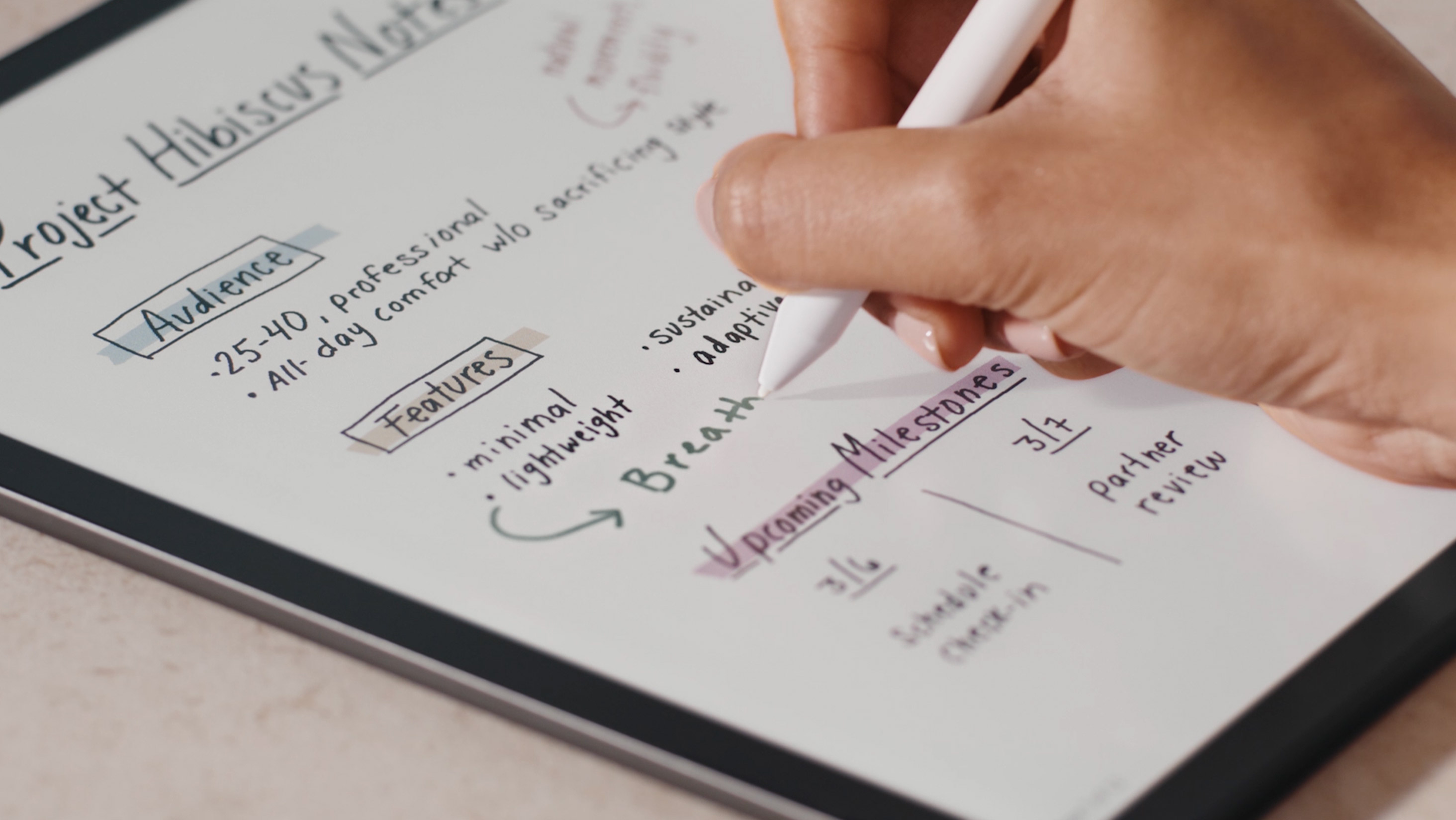 Primer plano de una mano tomando notas de proyecto con resaltados a color en el Kindle Scribe Colorsoft