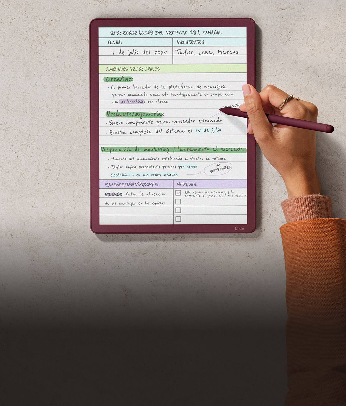 Mano escribiendo un acta de reunión en español con resaltados en varios colores en el Kindle Scribe Colorsoft