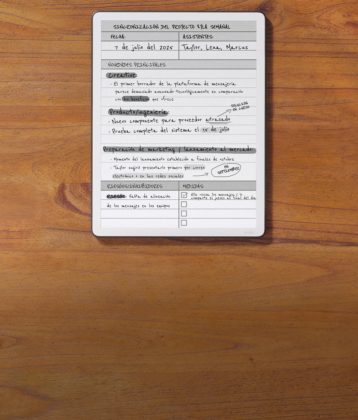Kindle Scribe sobre un escritorio de madera mostrando un acta de reunión escrita a mano en español