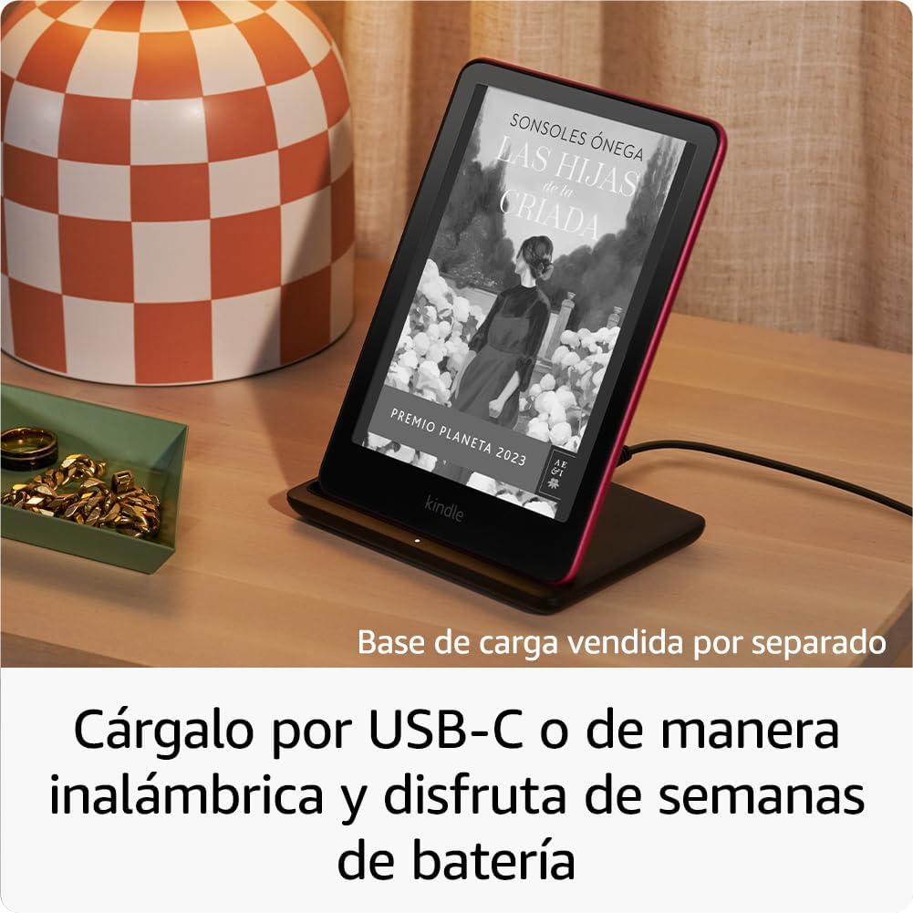 Kindle Paperwhite Signature cargando de forma inalámbrica en su base, sobre un velador